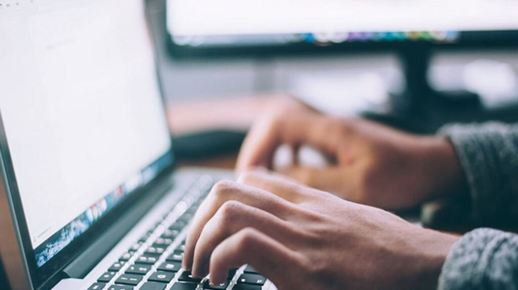 Zwei Hände beim Schreiben auf einem Laptop – Bild ist KI generiert